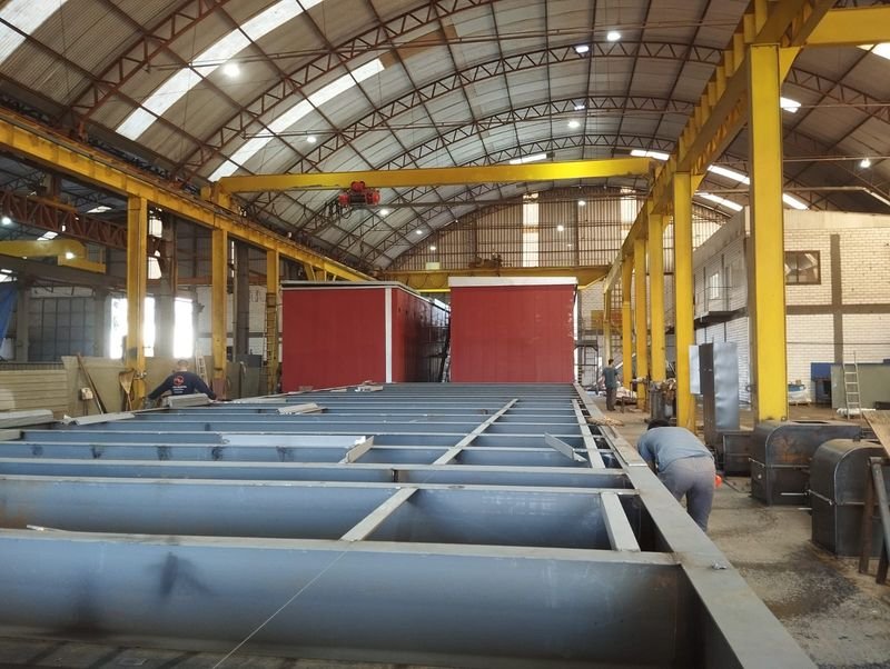 Base metálica de grande porte em fabricação, sob ponte rolante